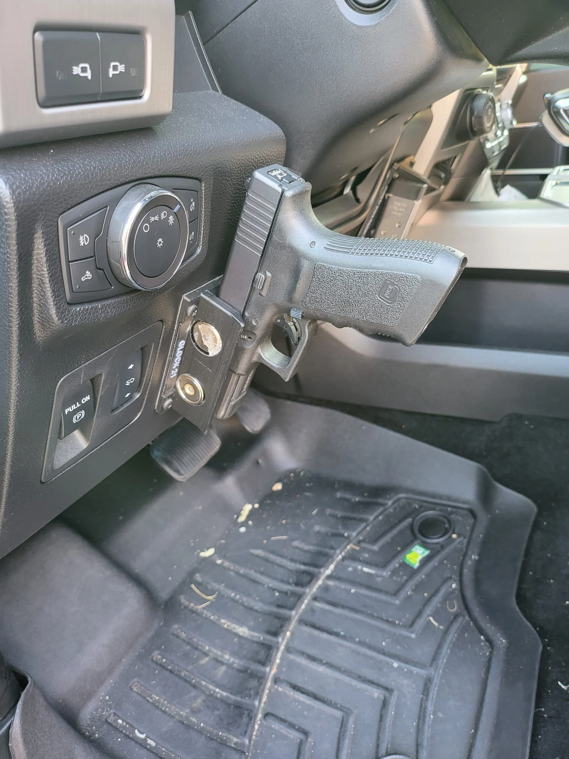 At The Ready pistol mount positioned on the lower dashboard panel of a vehicle